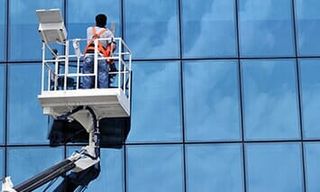 Cleaning Services — Man Washing The Window of Building in Crown Point, IN