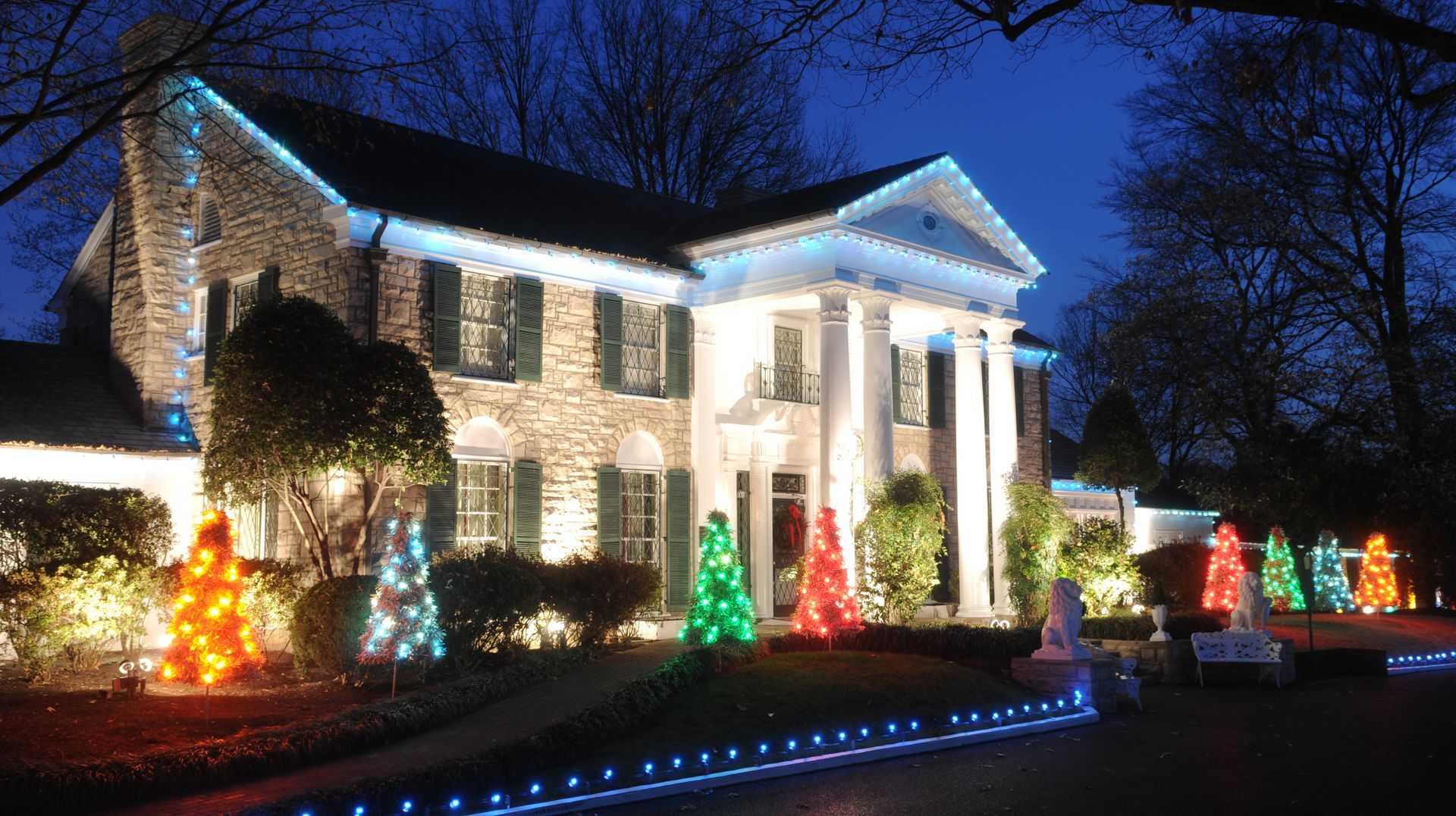 Das Herrenhaus Graceland erstrahlt nachts in blauem und farbigem Weihnachtslicht.