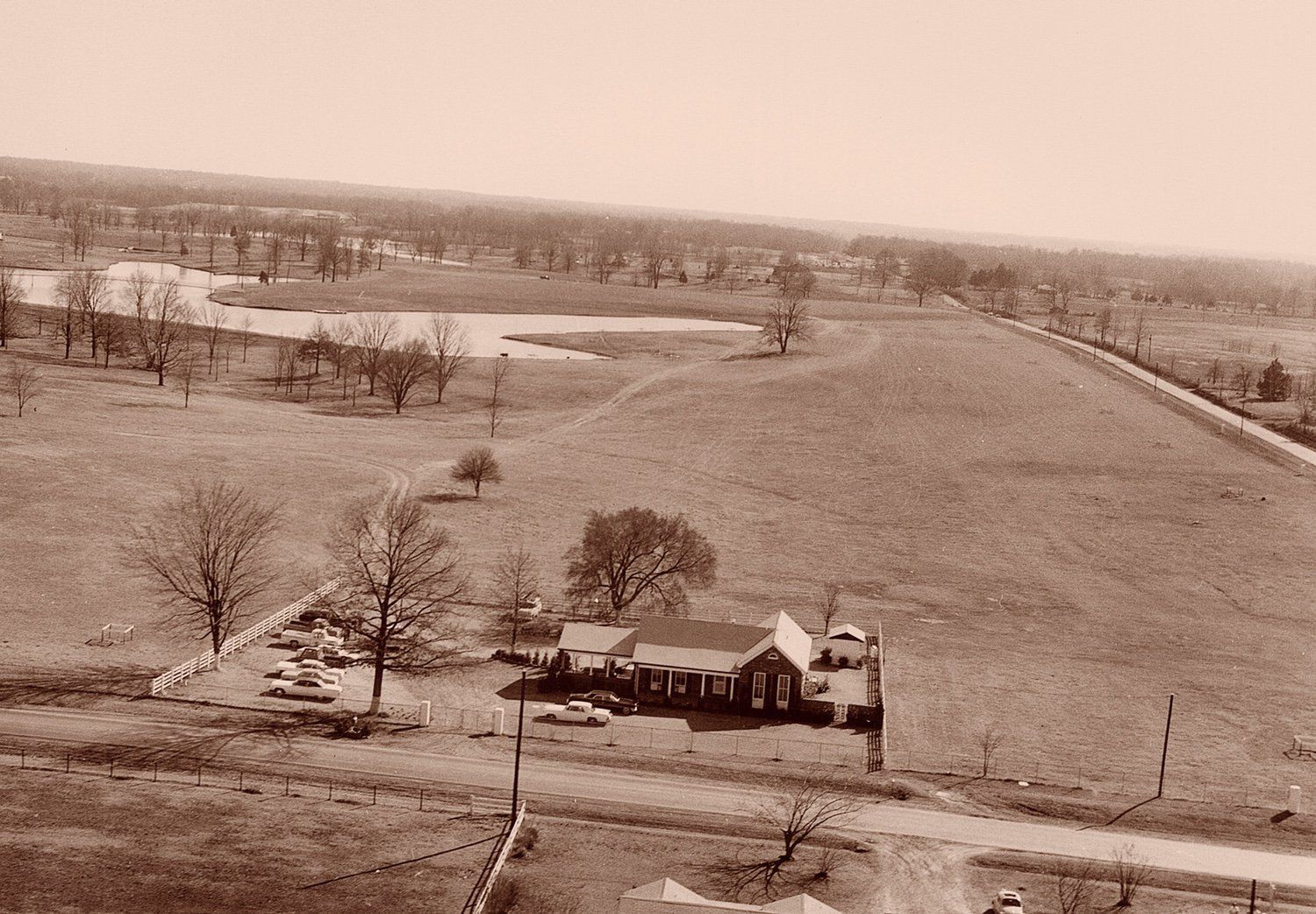 A black and white photo of a house in the middle of a field