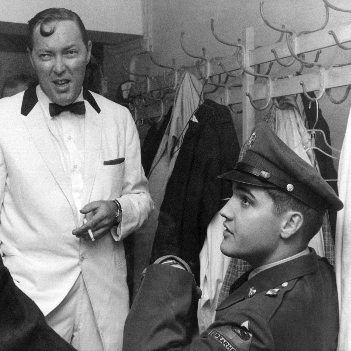 Bill Haley im Smoking spricht hinter der Bühne Elvis in Uniform.