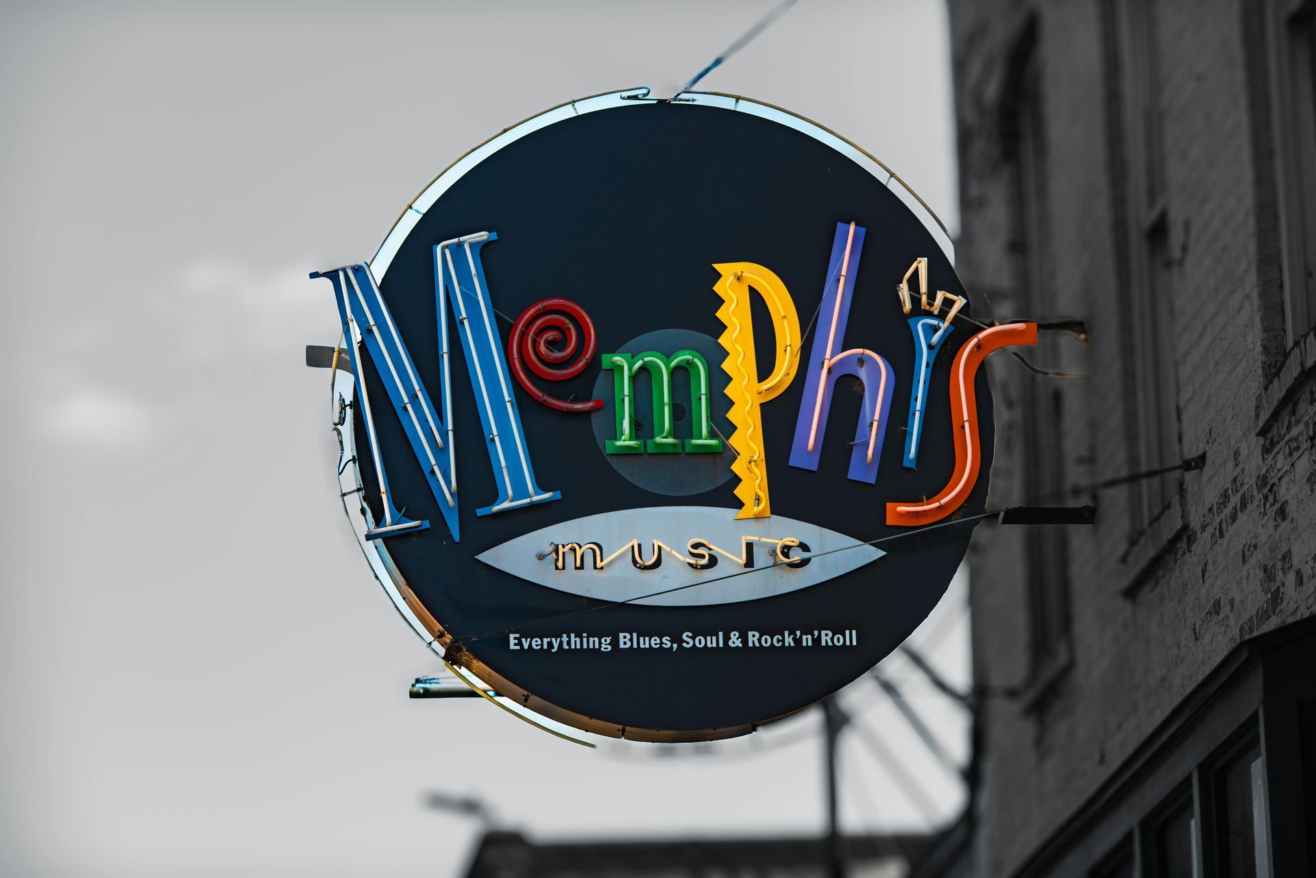 Neonsign Memphis vor einer grauen Hauswand