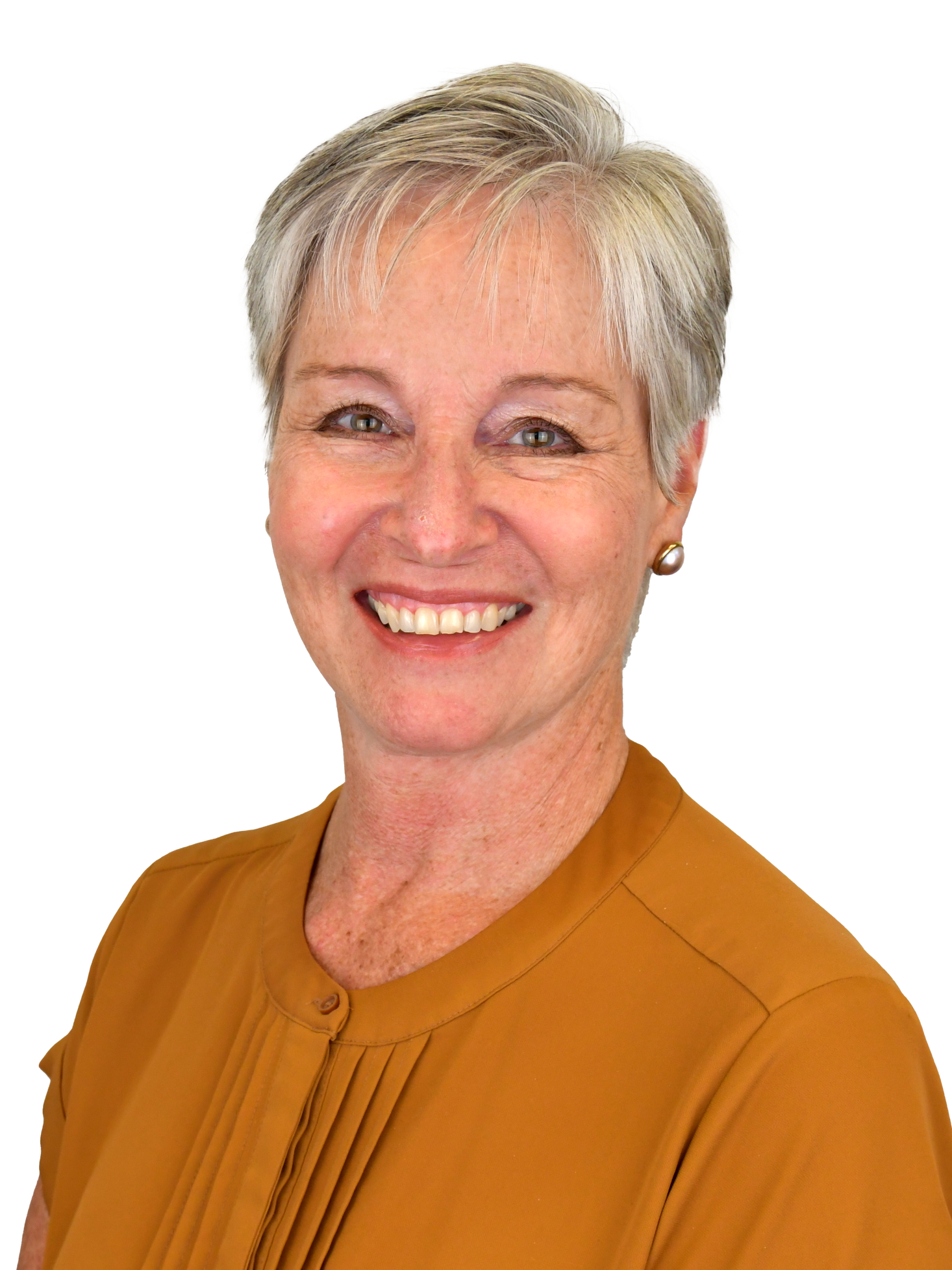 A woman in a yellow shirt is smiling for the camera.