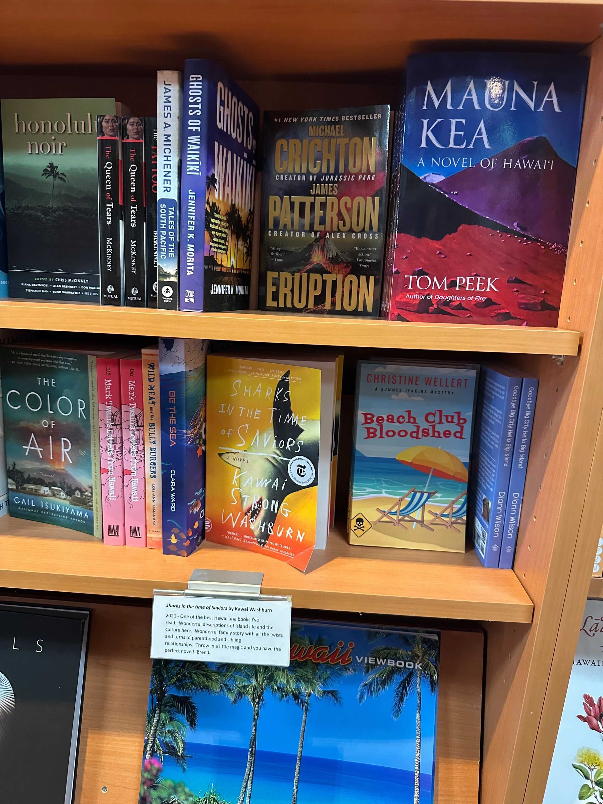 Books on shelves in a bookstore. Titles include 