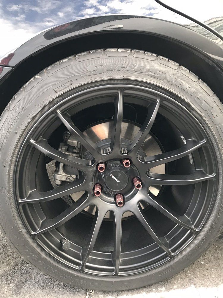 A close up of a black car wheel with a tire on it.