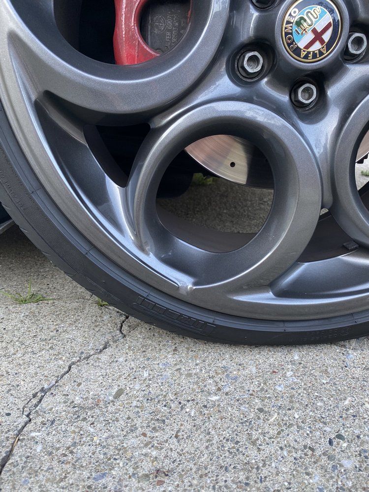A close up of a car wheel with a logo on it