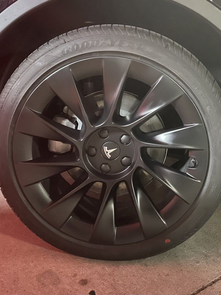 A close up of a black wheel on a tesla model 3.