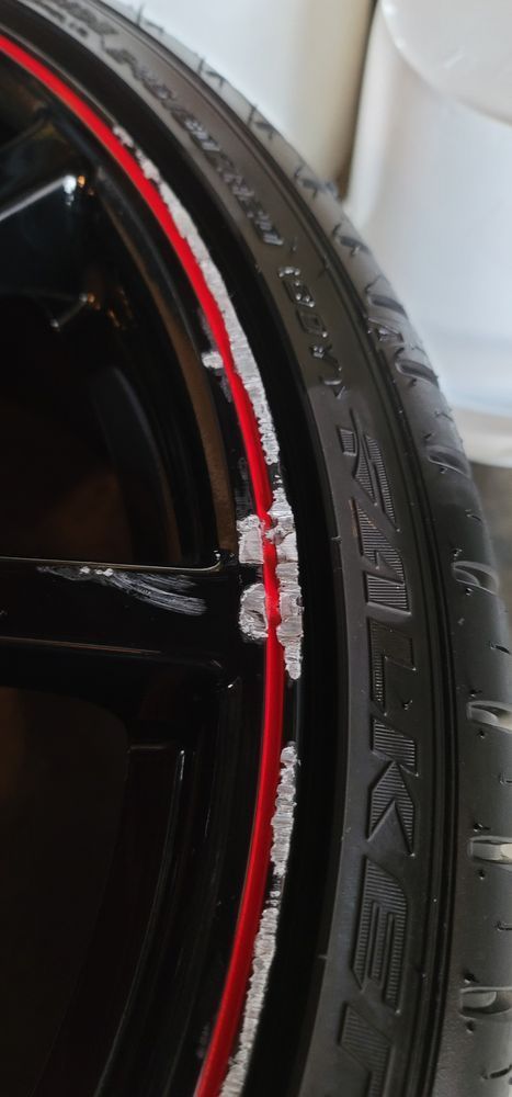 A close up of a black tire with a red rim