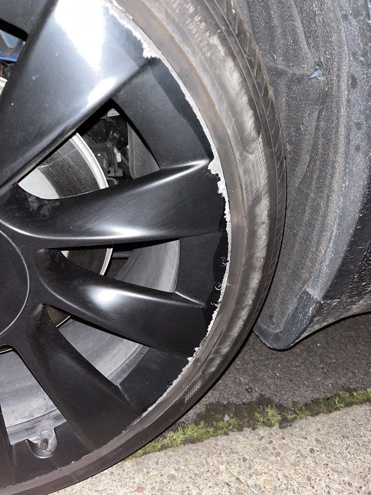 A close up of a car wheel with a damaged tire.