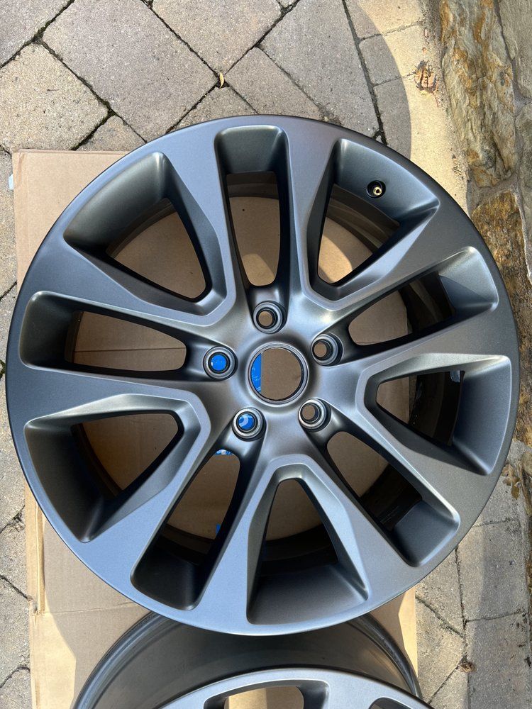 A pair of wheels are sitting on top of each other on a brick sidewalk.