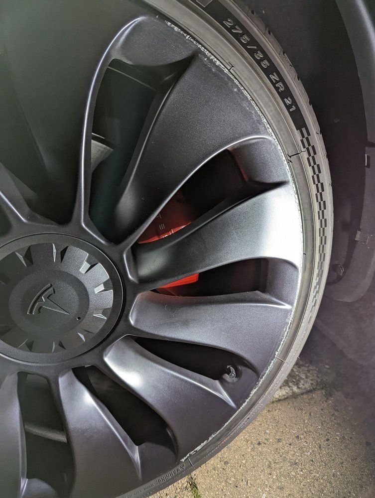 A close up of a tesla model 3 wheel with a tire on it.