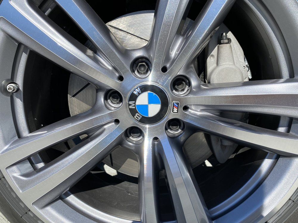 A close up of a bmw wheel with a bmw logo on it.