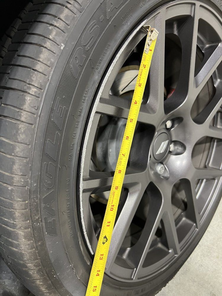 A close up of a tire with a tape measure on it