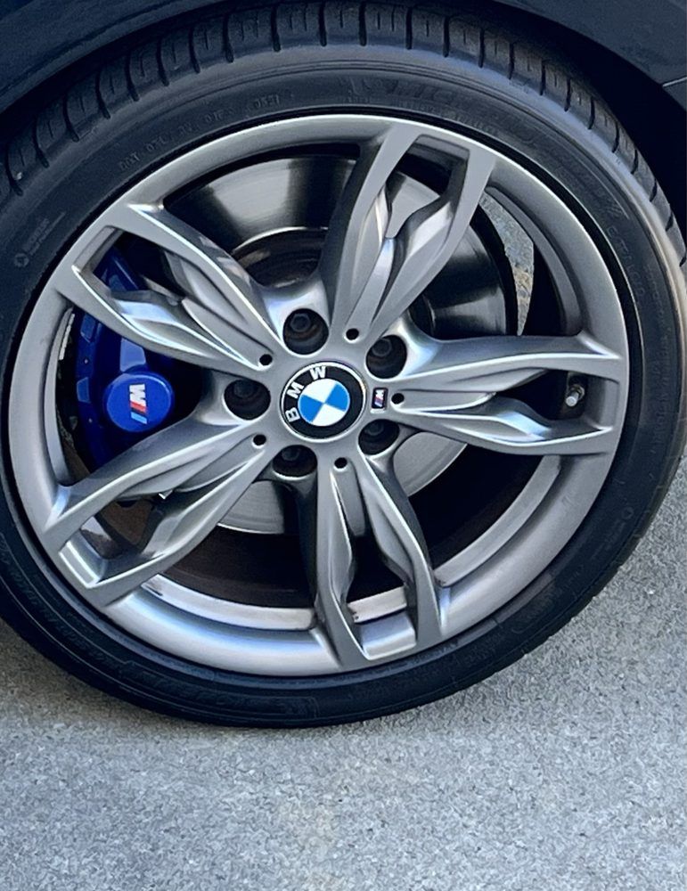 A close up of a bmw wheel with a blue brake caliper.