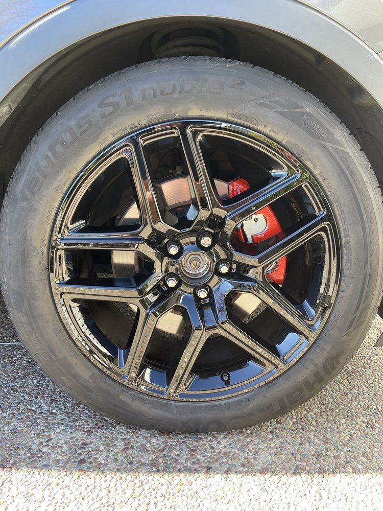 A close up of a black car wheel with a tire on it.