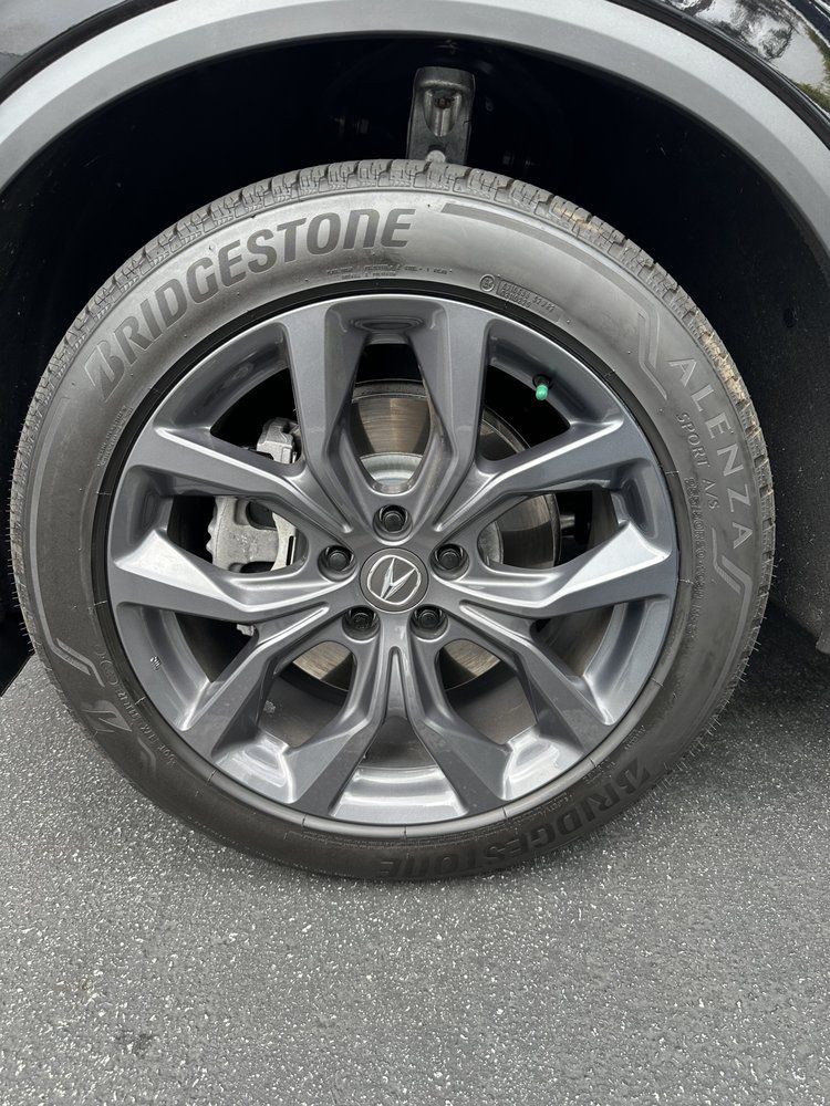A close up of a car wheel with a bridgestone tire on it.