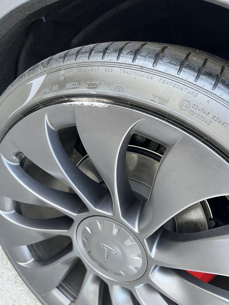 A close up of a tesla model 3 wheel with a tire on it.