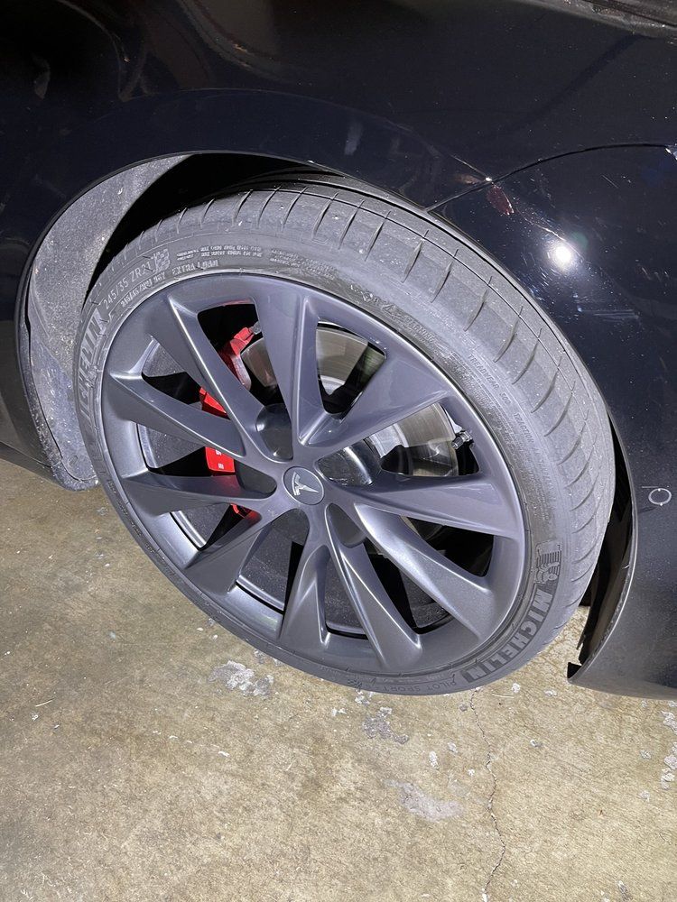A close up of a tire on a tesla model 3.