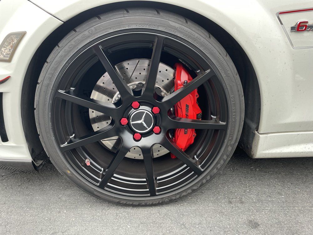 A close up of a car wheel with red brake calipers