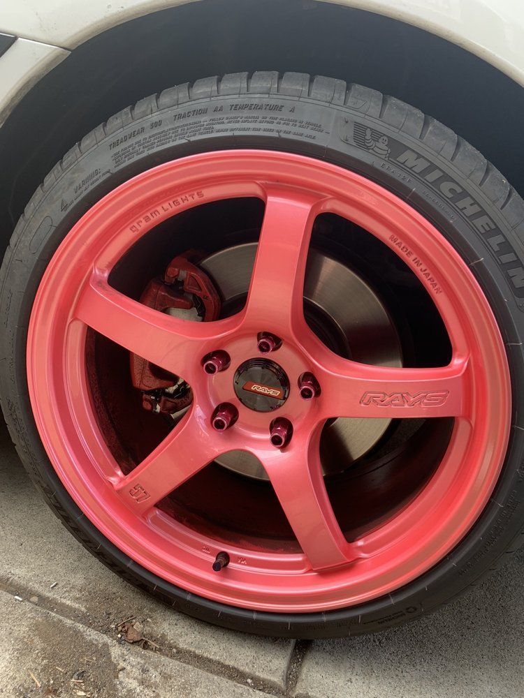 A close up of a red michelin tire on a white car