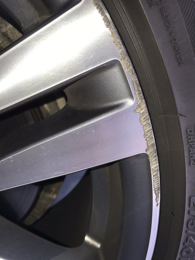 A close up of a car wheel with a damaged rim