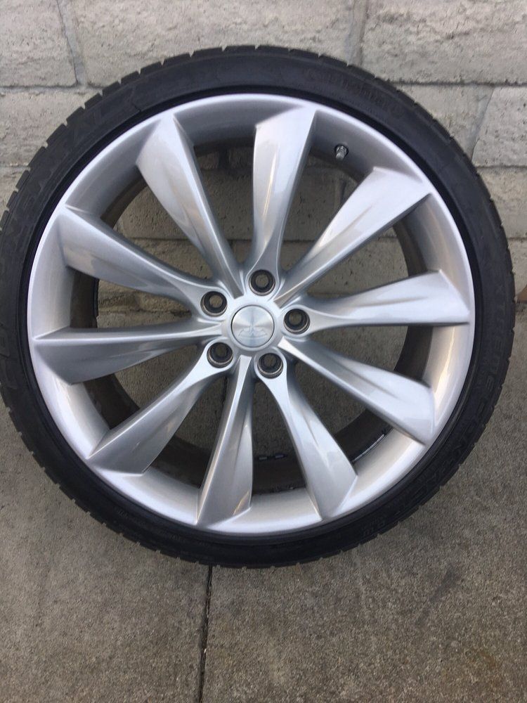 A close up of a tesla wheel with a tire on it.