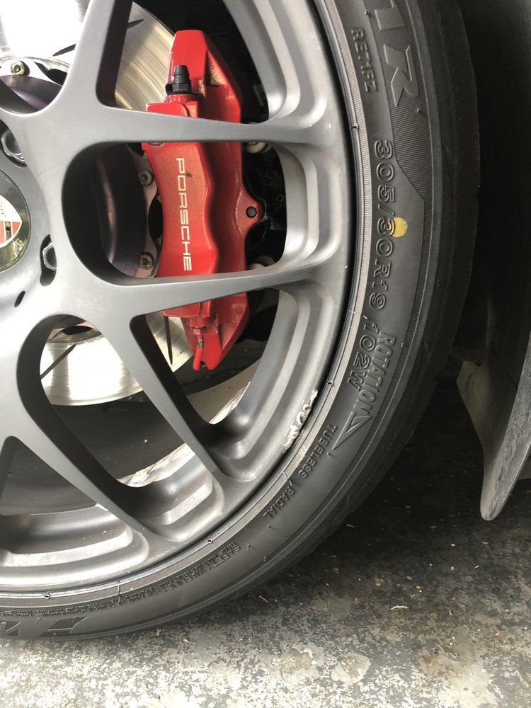 A close up of a porsche wheel with a red brembo brake