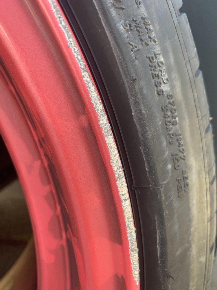 A close up of a tire with a red rim