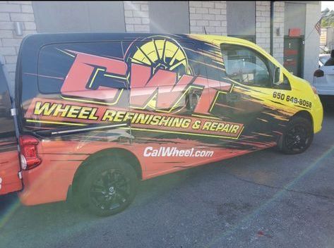 A wheel refinishing and repair van is parked in front of a building.