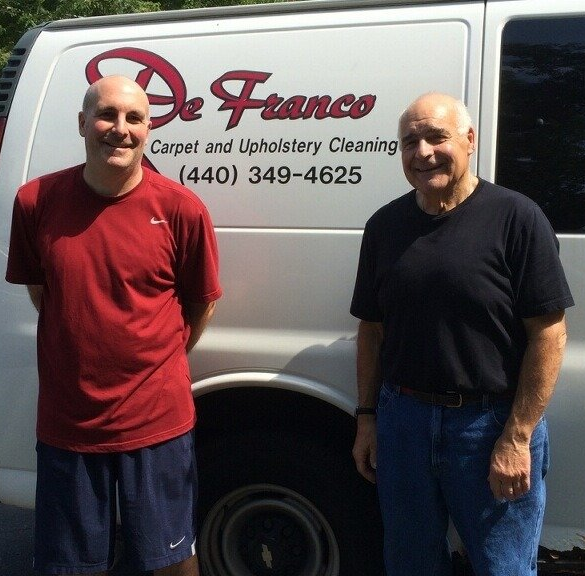Tony and Joe Deranco standing in front of a white De Franco Carpet and Upholstery Cleaning van with the phone number 440-349-4625.