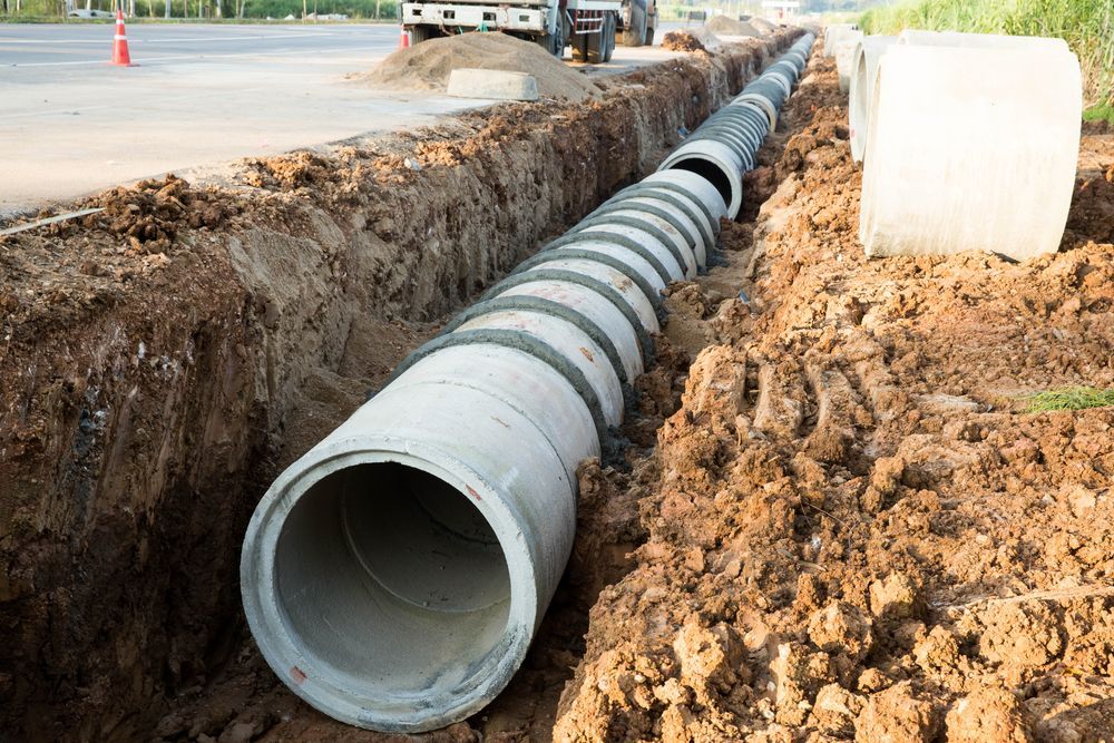 A Concrete Pipe Is Being Installed In The Dirt — Allsites Earthworx In Garbutt, QLD