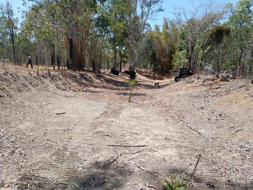 A Dirt Road In The Middle Of A Forest With Trees On Both Sides — Allsites Earthworx In Garbutt, QLD