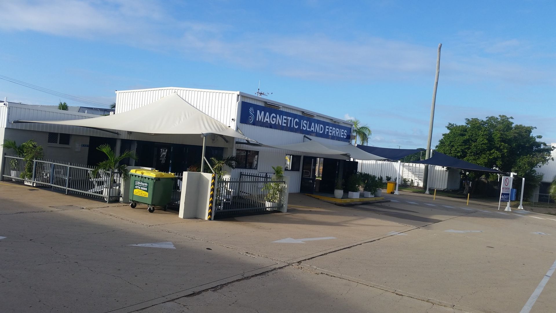 A White Building With A Blue Sign On It Is Sitting On The Side Of A Road — Allsites Earthworx In Garbutt, QLD