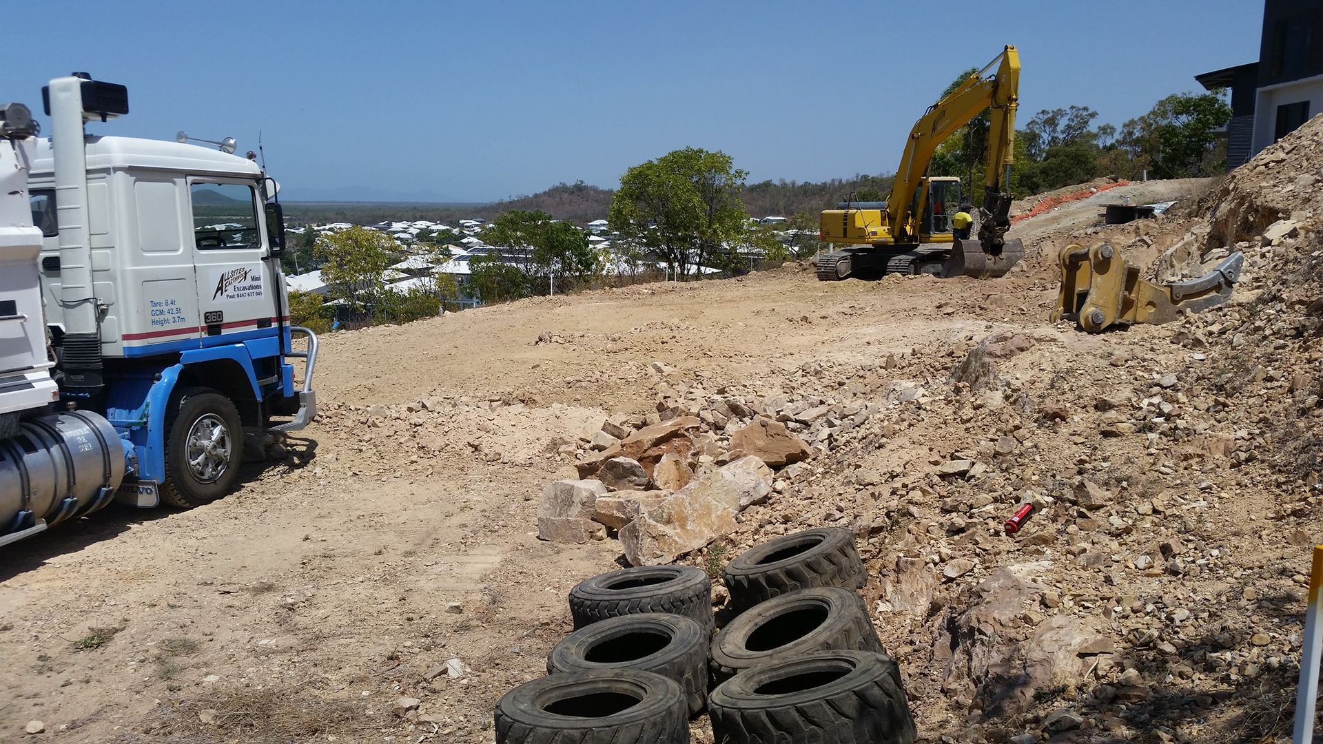 A White Truck Is Parked Next To A Pile Of Tires — Allsites Earthworx In Garbutt, QLD