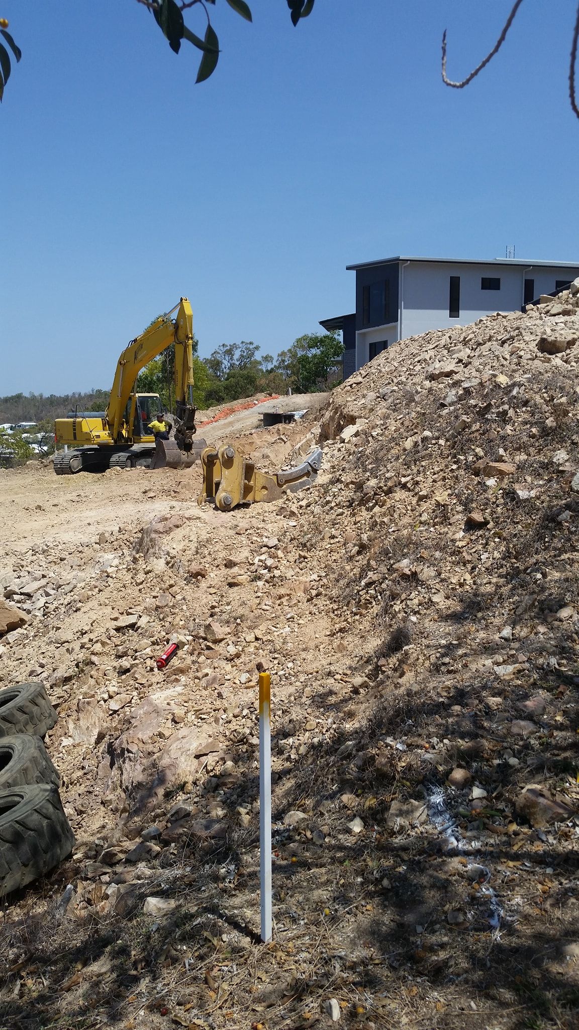 A Construction Site With A Large Pile Of Dirt And A Yellow Excavator — Allsites Earthworx In Garbutt, QLD