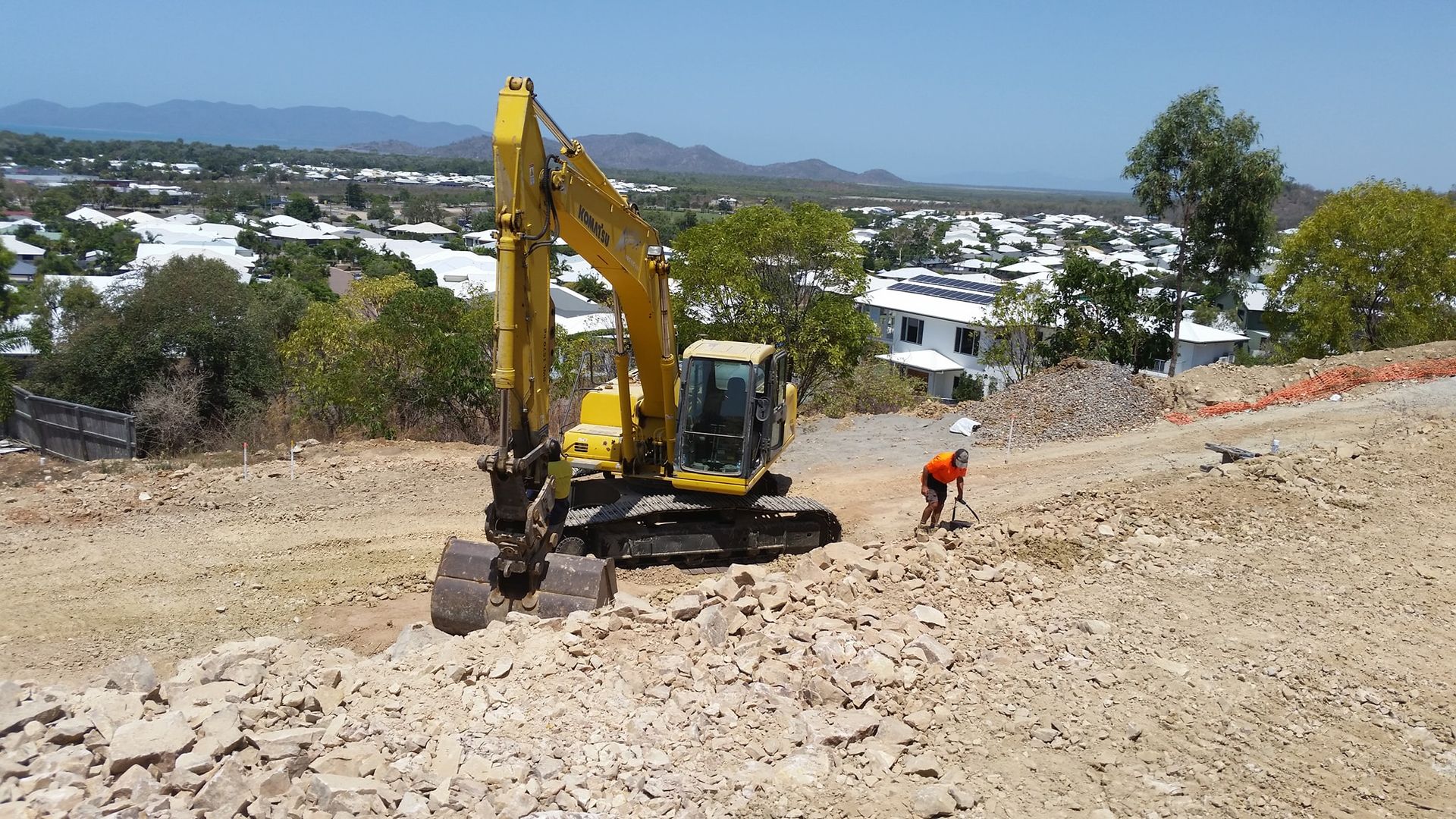 A Yellow Excavator Is Sitting On Top Of A Dirt Hill — Allsites Earthworx In Garbutt, QLD