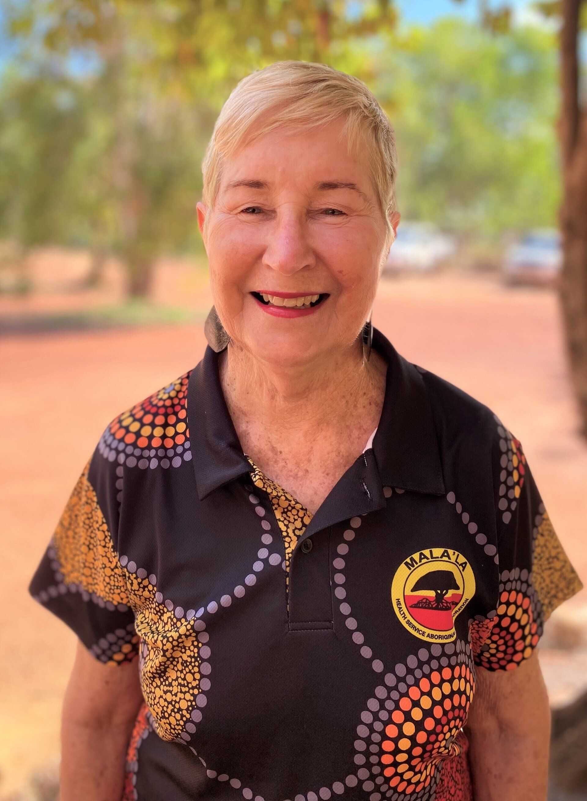 A woman in a black shirt is smiling for the camera.