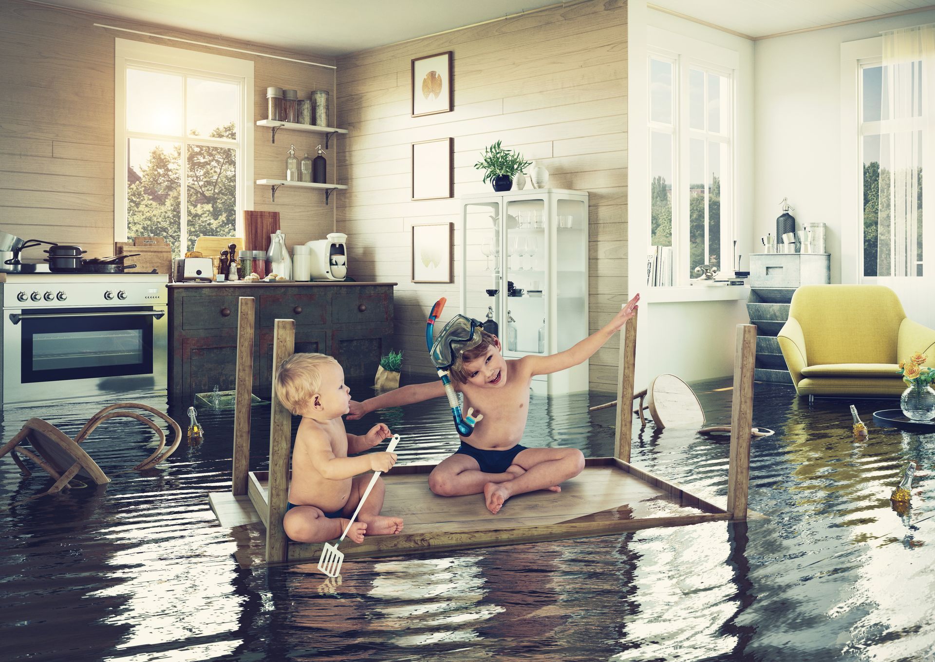 Children play on a makeshift raft in a flooded kitchen.