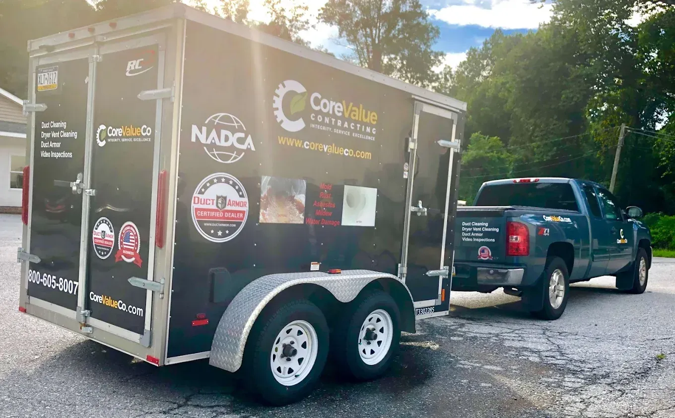 Truck pulling a trailer for Core Blue Contractors, parked on asphalt.
