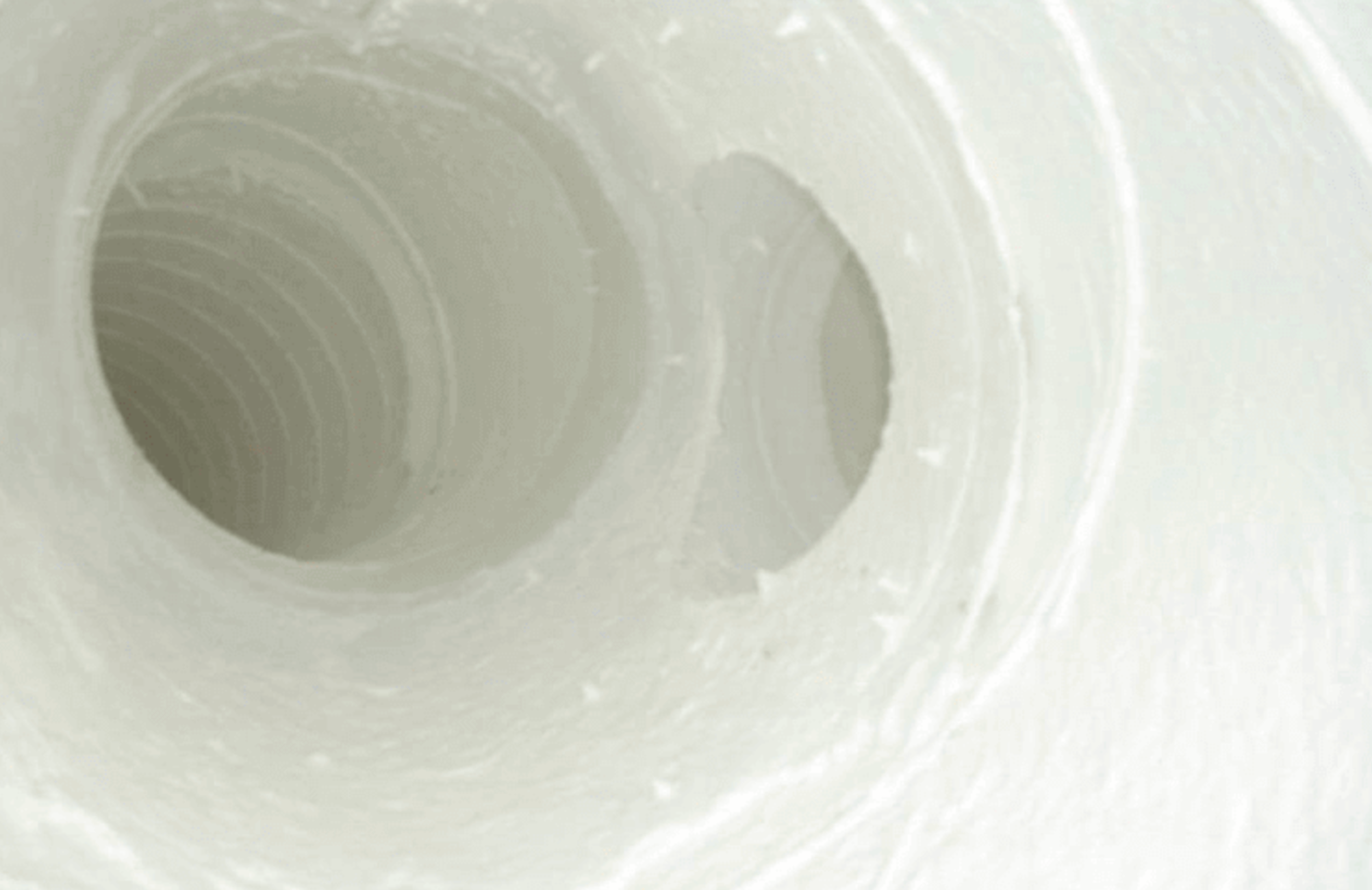 A roll of white, spiraling paper with several holes visible.