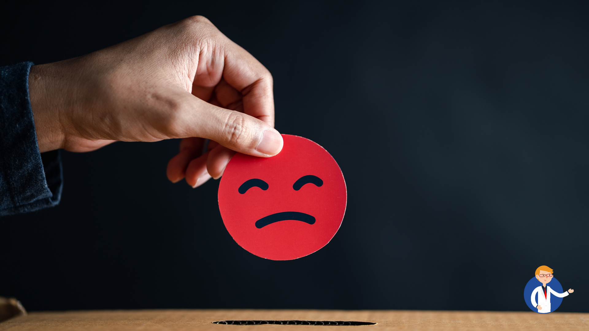 A person is holding a red circle with a sad face on it.