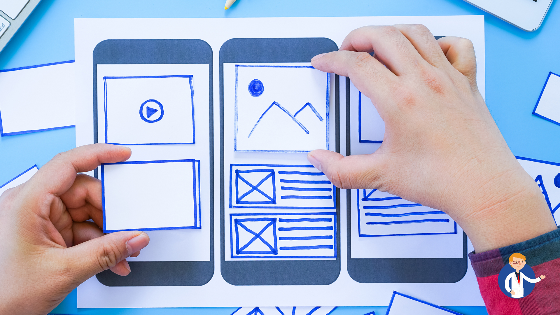 Hands arranging paper cutouts of mobile app screens on a blue surface, sketching layout.
