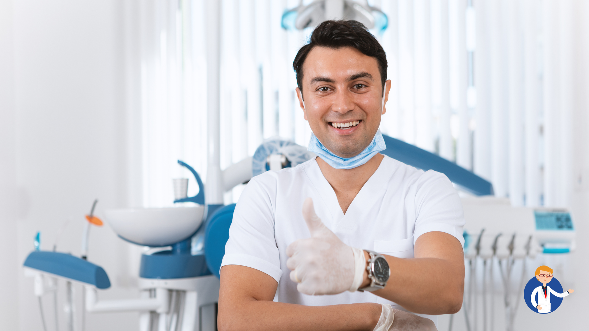 Dentist in white scrubs gives thumbs up, smiling in dental office.