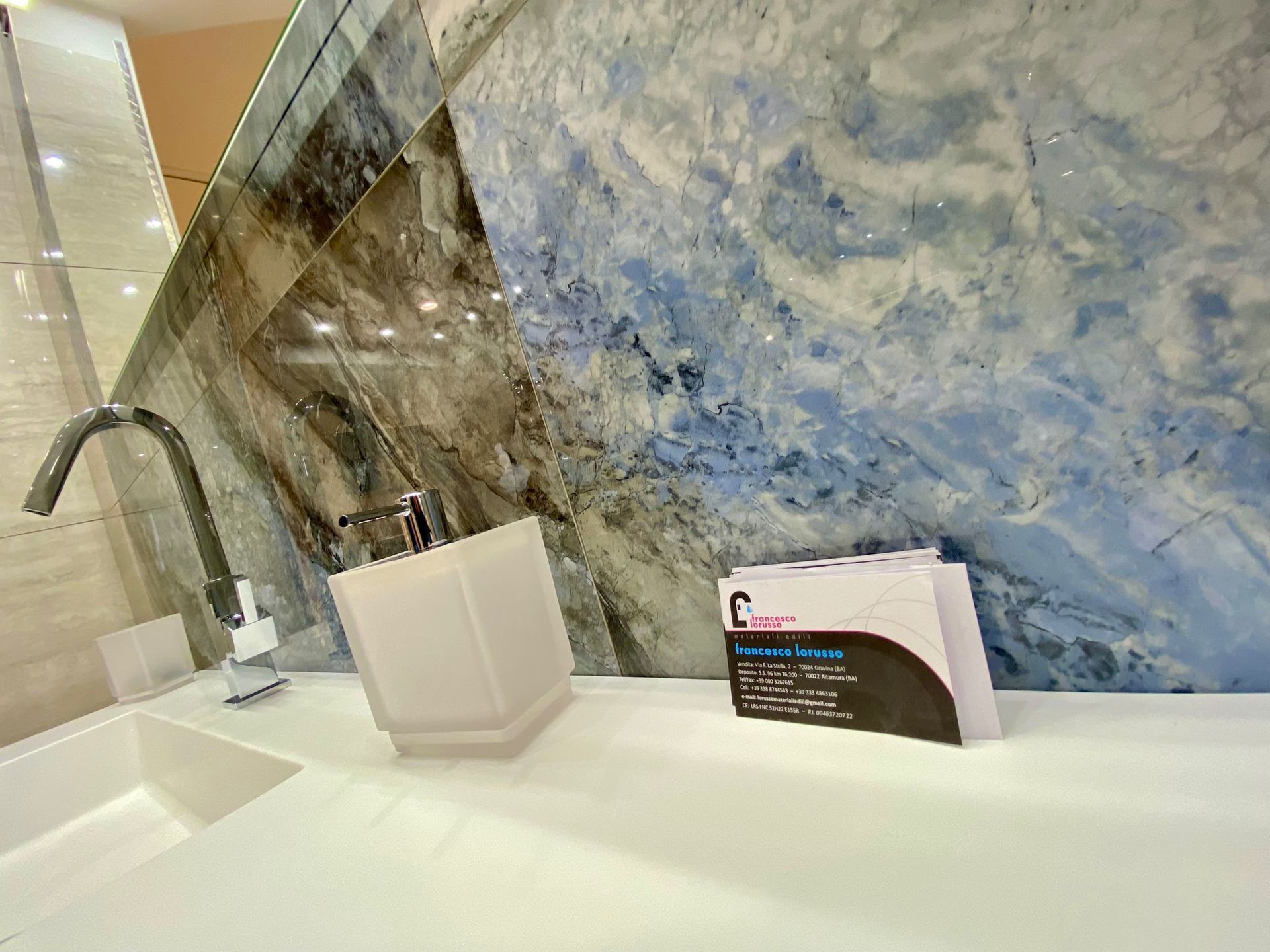 Un lavandino del bagno con un dispenser di sapone e una carta sopra.