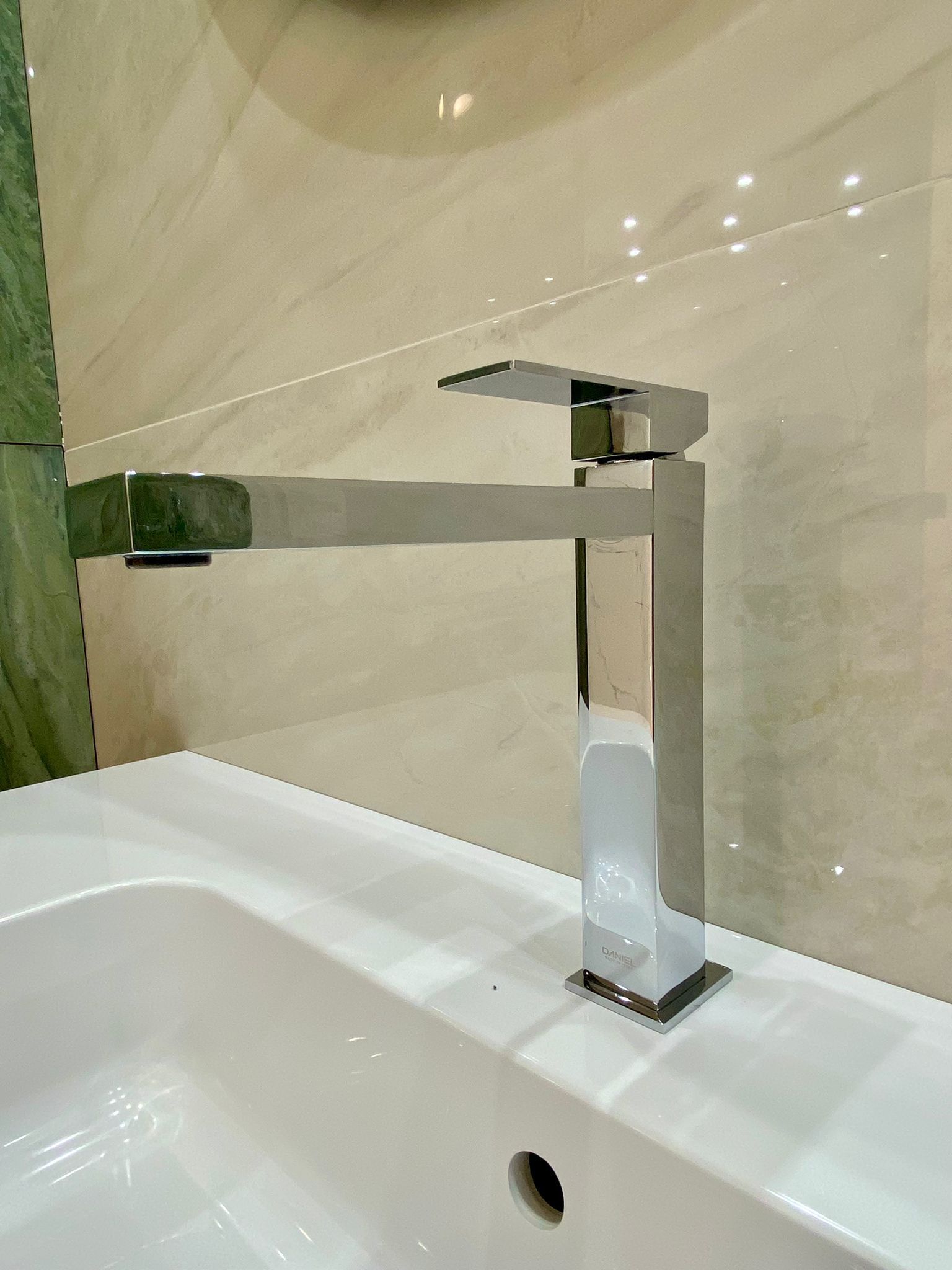 Un lavandino del bagno con sopra un rubinetto cromato.