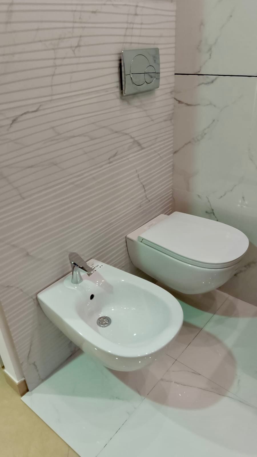 Un lavandino del bagno con rubinetto cromato e specchio.