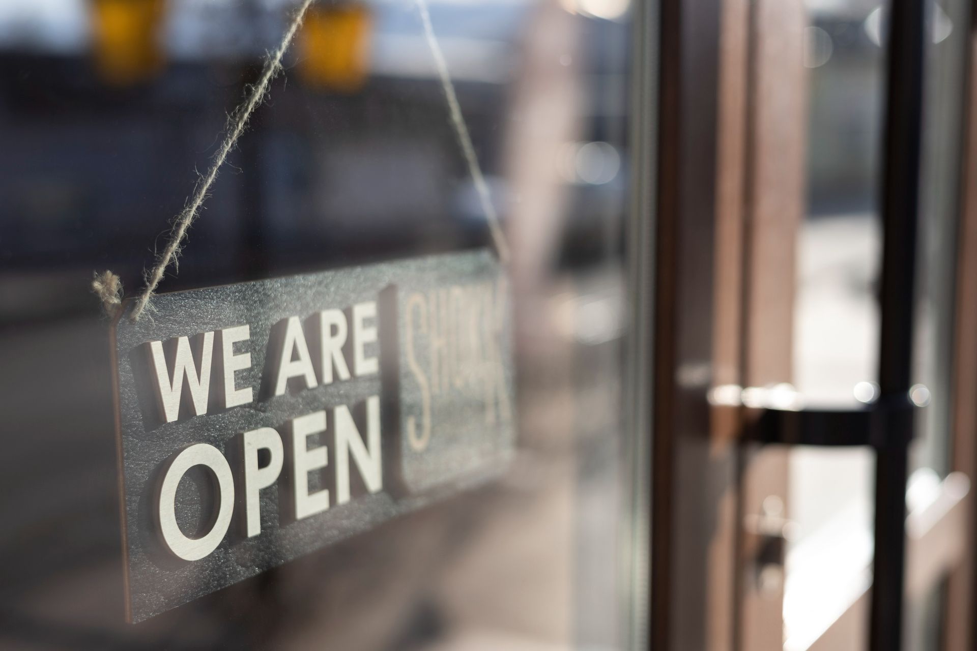 “We are open” sign hanging in a storefront window