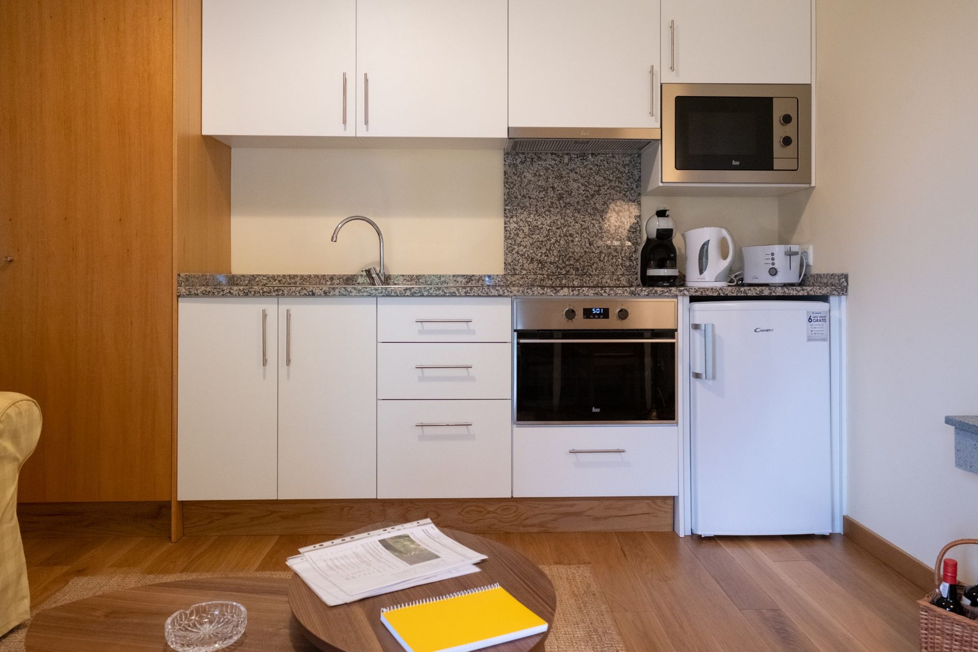 Small kitchen with white cabinets, appliances, and a microwave.