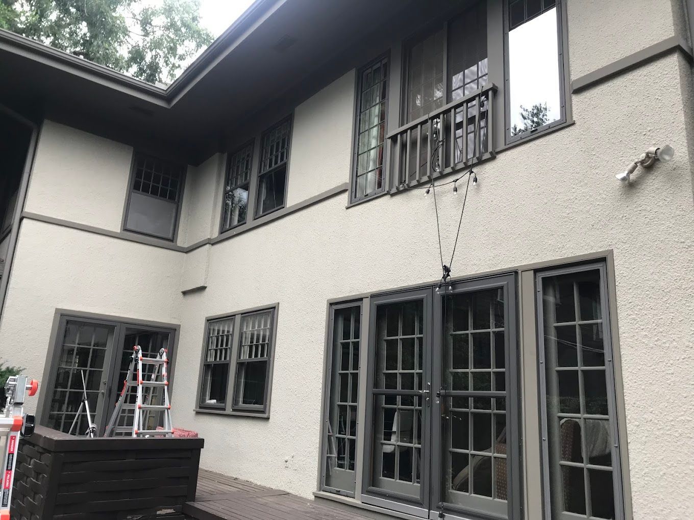 A large house with a lot of windows and a ladder in front of it.