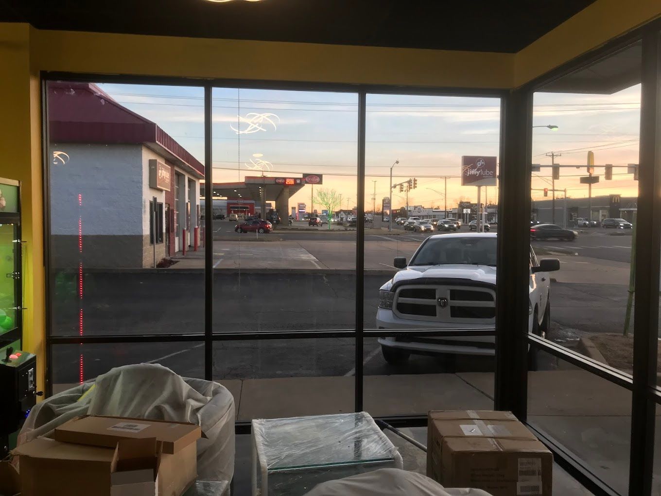 A white truck is parked in front of a gas station.
