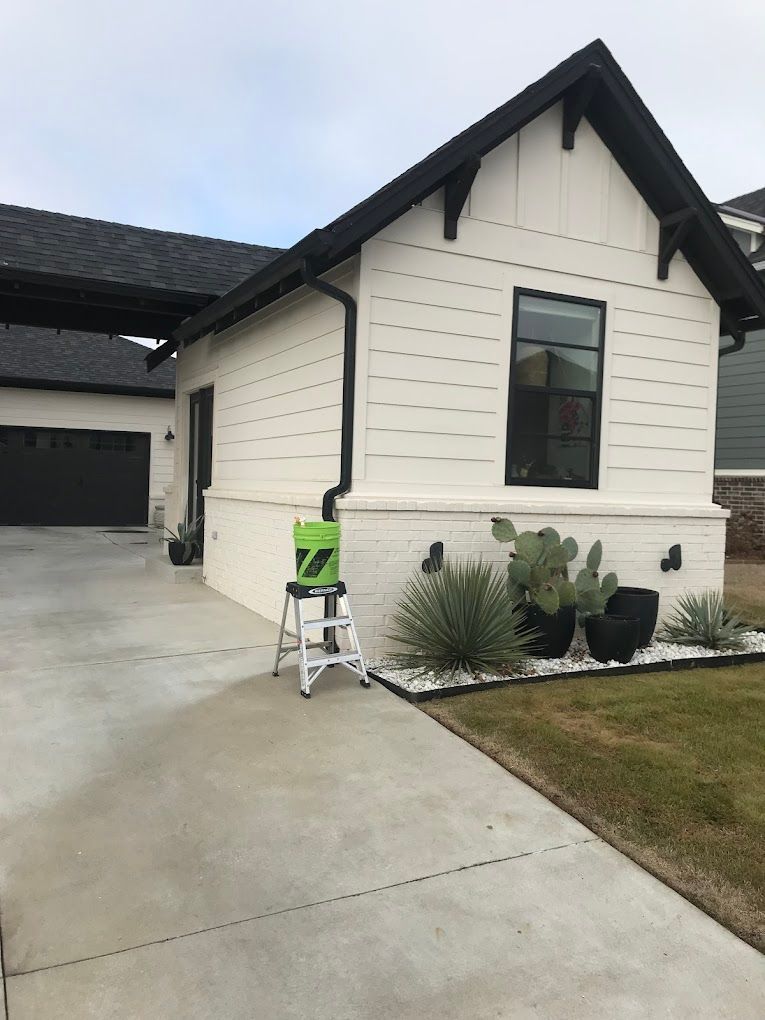 A white house with a green stool in front of it